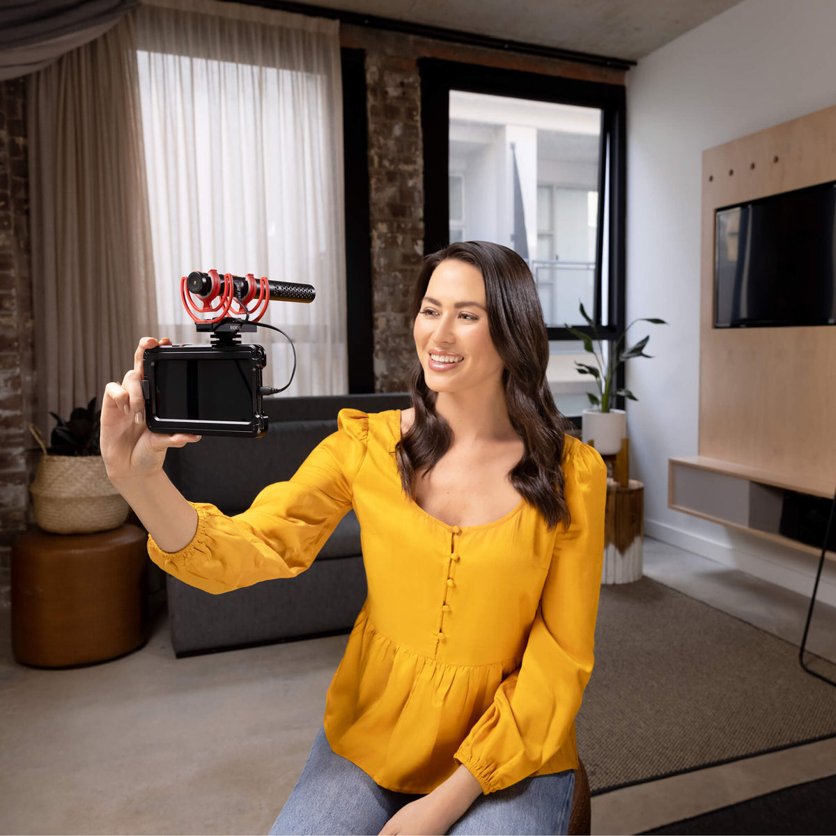 Rode SC15 USB C cable with video microphone, shown in a scene with a girl using a smartphone indoors.
