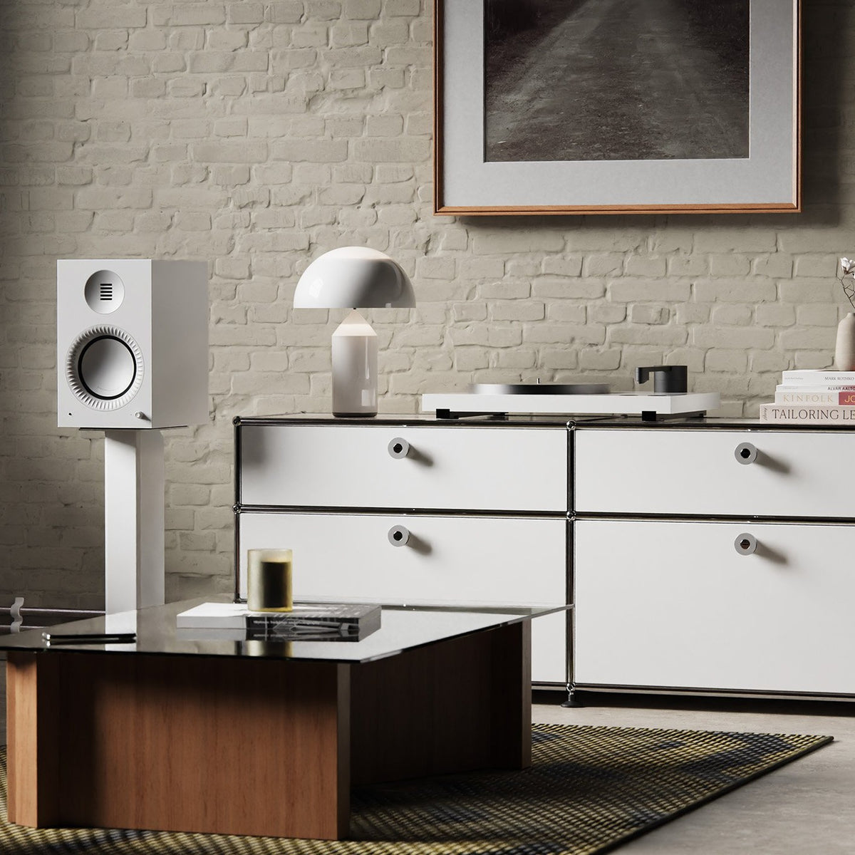 Kanto Audio TUK Grand in Matte White on stands beside a sideboard against a brick wall