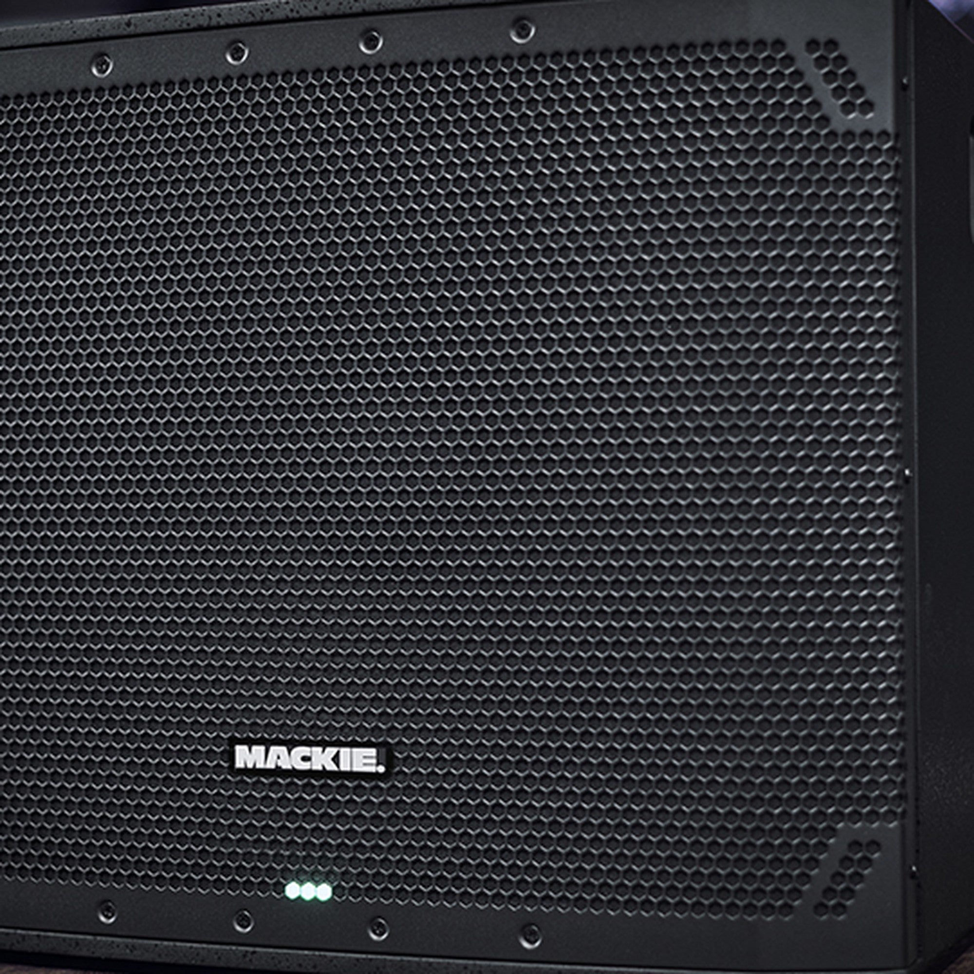 Close-up of Mackie Thump15Sv4 active subwoofer showing its rugged speaker grille and control panel for powerful bass output.